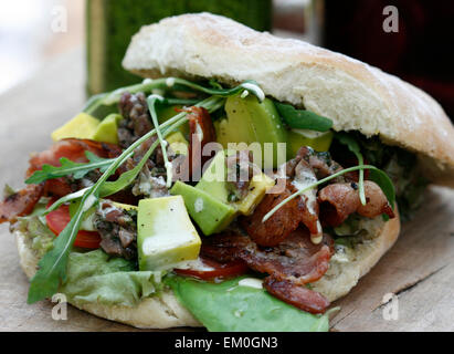 Bacon, laitue, avocat, tomate et tapenade d'olive dans un petit pain focaccia sandwich Banque D'Images