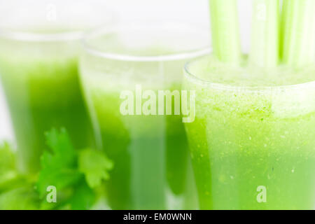 Le céleri et trois verres avec du jus de céleri isolated on white Banque D'Images