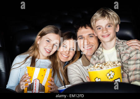 Famille heureuse avec le pop-corn au cinéma théâtre Banque D'Images