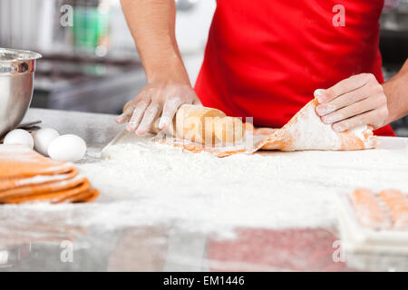 Chef holding Rolling pin lors de la préparation de pâtes à raviolis kitche Banque D'Images