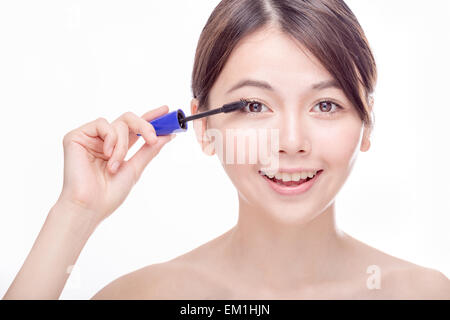 Chinese woman putting mascara sur les cils Banque D'Images