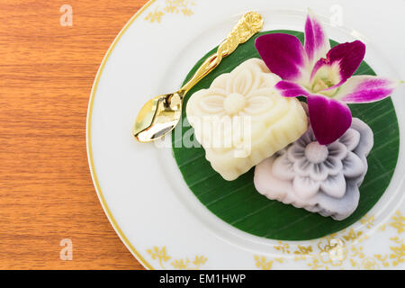 Deux gâteaux japonais placé sur des feuilles de banane avec cuillère d'Or et orchidée, fleur Banque D'Images