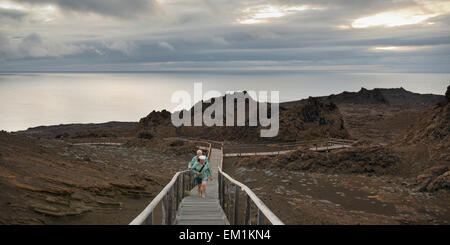 Deux personnes marchant sur un trottoir de bois ; Bartolome Island Galapagos Équateur Banque D'Images