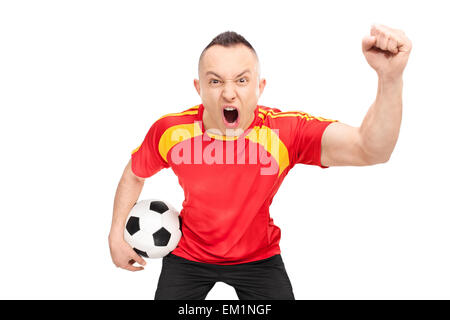 Les jeunes sports fan extatique dans un maillot de football rouge holding a football et acclamer isolé sur fond blanc