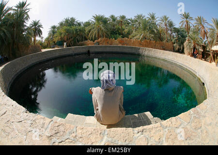 Un homme regarde dans Siwan Local Cleopatra's Pool A l'eau douce naturelle de printemps à l'oasis de Siwa Siwa Siwa Egypte ; Banque D'Images