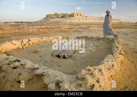 Un homme regarde à Siwan locales une fosse peu profonde à l'extérieur du site Siwa Town à l'oasis de Siwa Siwa Egypte ; Banque D'Images