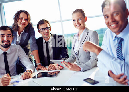 Les collègues de travail élégant à la caméra pendant au meeting in office Banque D'Images