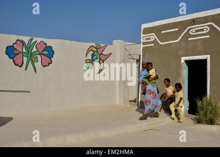 Femme avec enfants, peint en couleurs maison du village nubien dans Umogaal Dongola, Nubie, Soudan Banque D'Images