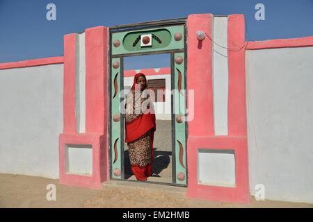 Femme nubienne typique en robe lumineuse, devant sa maison, dans le village d'Umogaal à Dongola, vallée du Nil, de la Nubie, Soudan Banque D'Images