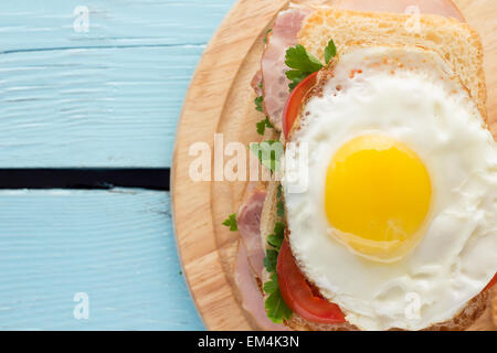 Sandwich au porc fumé, tomate et œuf frit vue supérieure horizontale Banque D'Images