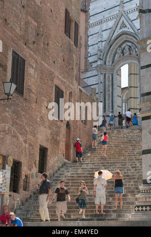 Italie Voyage, vue en été des touristes monter l'escalier à l'extrémité ouest du Duomo (cathédrale) à Sienne, Toscane, Italie. Banque D'Images