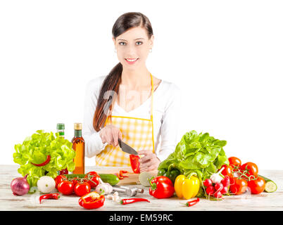 Jeune femme de la préparation de la salade. L'alimentation saine et l'alimentation de concept. Isolé sur blanc. Banque D'Images