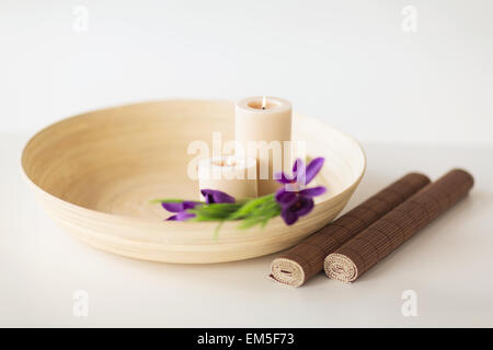 Bougies et fleurs de l'iris dans l'intestin en bois et tapis Banque D'Images