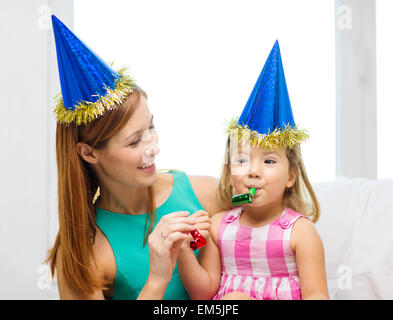 Mère et fille en bleu casquettes avec faveur cornes Banque D'Images