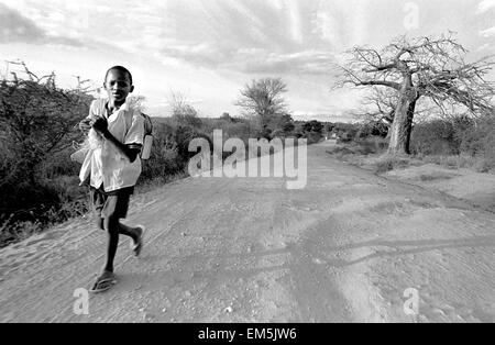 Ikutha, Kitui, Kenya. Les enfants qui fréquentent l'école aile sont forcés de marcher pendant plusieurs heures sur les routes poussiéreuses. Cette localité rurale, ha Banque D'Images