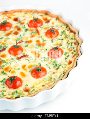 Quiche aux tomates cerises et les herbes sur une plaque blanche Banque D'Images