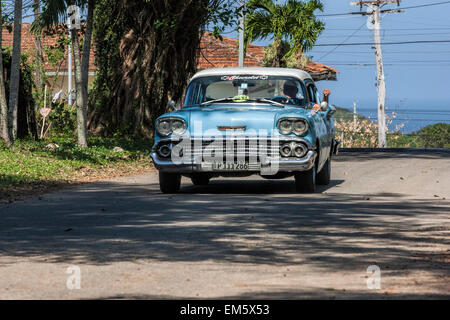 Vieille voiture américaine bleu sur une route dans une région éloignée de Cuba Banque D'Images