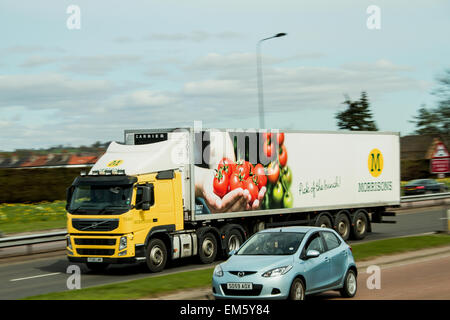 Panoramique avec une synchro flash arrière de camions Morrisons voyageant le long de la Kingsway West à deux voies dans Dundee, Royaume-Uni Banque D'Images