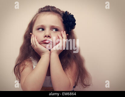 Belle fille à la triste avec la moue des lèvres. Closeup portrait of cute kid avec les cheveux longs. VIntage Banque D'Images