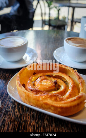 Un pain aux raisins de style français avec du café Banque D'Images