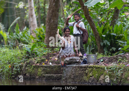 Femme et enfant en agitant les bras morts, système de canaux en Alappuzha, Kerala, Inde Banque D'Images