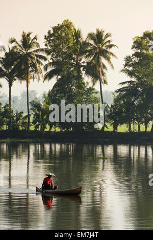 Pêcheur dans un petit bateau en bois, backwaters, Kerala, côte de Malabar, en Inde du Sud, Inde Banque D'Images