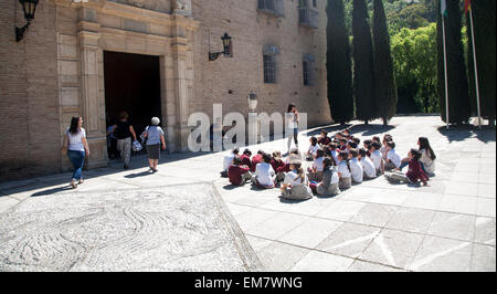 Les enfants de l'école d'écouter leur professeur sur une visite éducative pour les sites historiques de Grenade, Espagne Banque D'Images