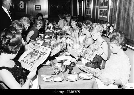 1966 Tournoi de Coupe du Monde en Angleterre. Un banquet a eu lieu la coupe du monde pour l'équipe de l'Angleterre victorieuse au Royal Garden Hotel après leur victoire sur l'Allemagne de l'Ouest en finale à Wembley. Épouses des joueurs qui ont dû manger un dîner séparé de leur mari, y compris Mme Tina Moore, Mme Peters, Mme Hurst, Mme Springett et Mme Bonetti lire le journal Sunday Mirror. Le 31 juillet 1966. Banque D'Images