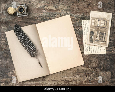 Livre ouvert, outils d'écriture vintage stylo-plume encrier et texturé sur fond de bois. Retro style tonique photo Banque D'Images