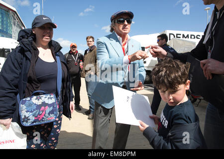 Sir Jackie Stewart, ancien légendaire pilote de course de Formule Un, de signer des autographes dans le circuit de course de Silverstone, Angleterre, RU Banque D'Images