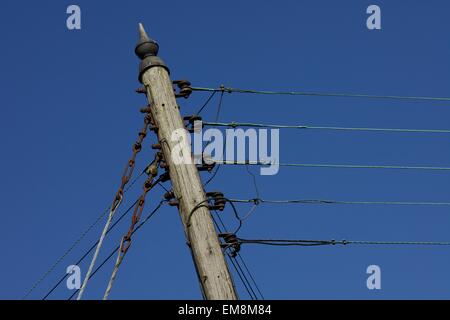 Poteau télégraphique traditionnel en bois contre un ciel bleu profond Banque D'Images