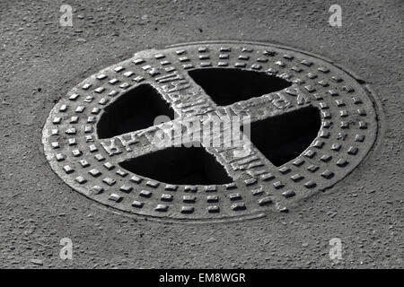 Trappe ronde en milieu urbain la route d'asphalte de la chaussée. Secours russe texte sur le cap signifie l'assainissement Banque D'Images