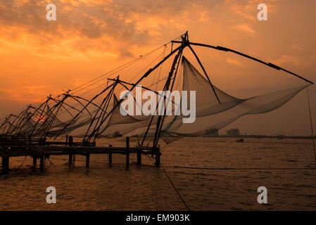 Coucher du soleil par les filets de pêche chinois à fort Kochi, Kerala Inde Banque D'Images