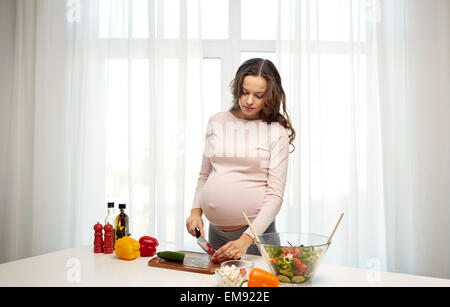 Pregnant woman preparing food at home Banque D'Images