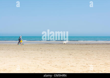 Italy-April,Rimini 12,2015:un couple seul avec le chien se promener sur la plage de Rimini près de la mer au cours d'une journée ensoleillée. Banque D'Images