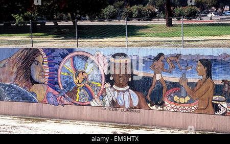 Peintures d'Indiens américains sont discutés au début de l'un des plus longs les murales, "l'histoire de Californie,' qui couvre un mur en béton du canal de contrôle d'inondation Lavage Tujunga à Los Angeles, Californie, USA. Connu comme la Grande Muraille de Los Angeles, la fresque s'exécute plus d'un demi-mile le long de Coldwater Canyon Avenue. Ce monument représente la création artistique des peuples ethniques de Californie de la préhistoire aux années 1950. Il est né en 1976 comme un projet d'embellissement de l'artiste Judy Baca, qui l'a enrôlé plus de 400 jeunes à la peinture murale énorme sur cinq étés. Banque D'Images