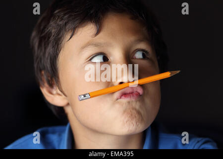 Jeune collégien avec crayon - avec éclairage clair-obscur - faible profondeur de champ Banque D'Images