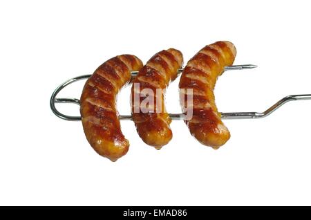 Saucisses fraîches sur fourche du grill sur fond blanc Banque D'Images