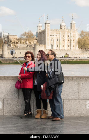 Londres, Royaume-Uni. 18 avril, 2015. Les touristes prendre une photographie à l'aide d'un bâton selfies en face de la Tour de Londres au cours du printemps ensoleillé météo à Londres. Credit : Londres pix/Alamy Live News Banque D'Images