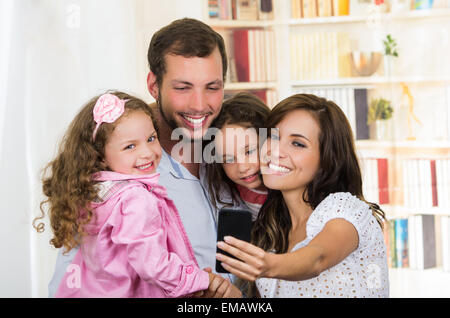 Jolie famille avec deux petites filles de prendre une photo selfies Banque D'Images