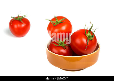 Les tomates fraîches dans un bol brun isolated over white background Banque D'Images