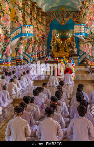 Fidèles priant et chantant dans le grand temple de Cao Dai, Banque D'Images