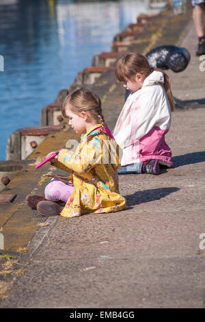 Poole, Dorset, UK 19 avril 2015. UK - sunny breezy day à Poole Quay, Dorset, UK - deux jeunes filles jouissent en crabe sur le quai Crédit : Carolyn Jenkins/Alamy Live News Banque D'Images