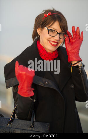 Belle jeune femme en souriant et saluant le long d'une journée d'hiver. Banque D'Images