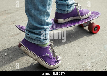 Jeune skateur professionnel en jeans debout sur son skate. Close-up fragment de skateboard et les pieds Banque D'Images