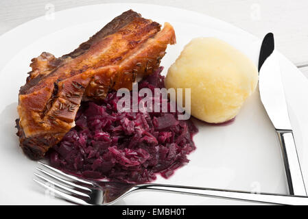 Rôti de porc assaisonné avec du carvi, crépitant et choucroute rouge style Allemand boulette de pommes de terre Banque D'Images