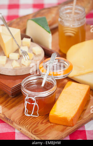 Deux types de miel artisanal, à l'avant, mixte, de fleurs sauvages et à l'arrière, Beek's Honey, et plusieurs variétés de fromages Banque D'Images