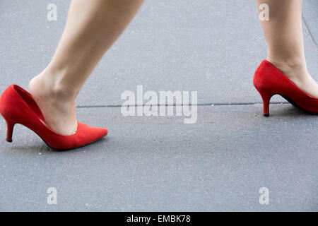 Gros plan d'un pied et de la jambe de la femme lui montrant ses chaussures comme elle marche dans New York City Banque D'Images