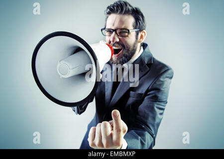 Young businessman yelling agressive sur le mégaphone Banque D'Images