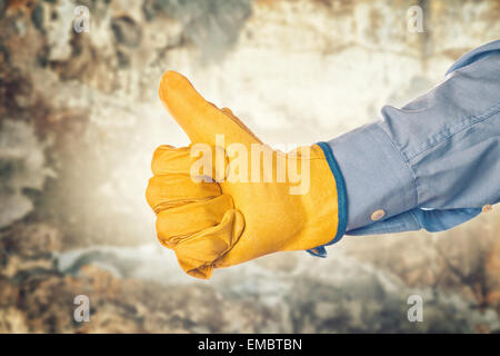 Ingénieur de construction portant des gants de protection en cuir jaune Gesturing Thumbs Up pour approbation Banque D'Images